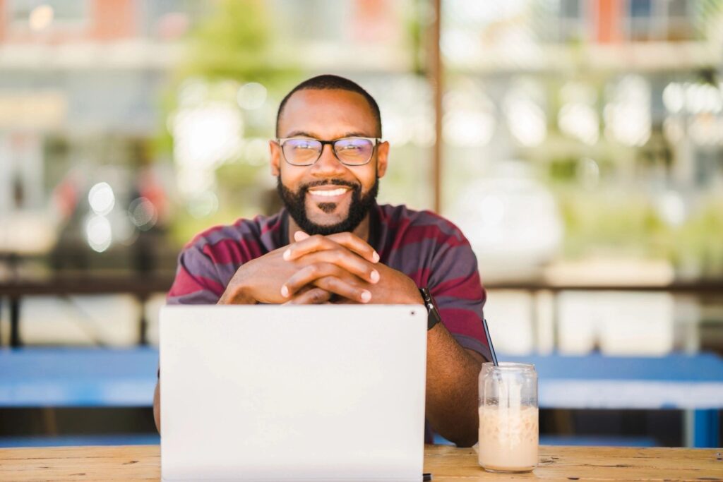 Small AE firm owner looking at computer with smile, searching for Deltek Ajera Consultants